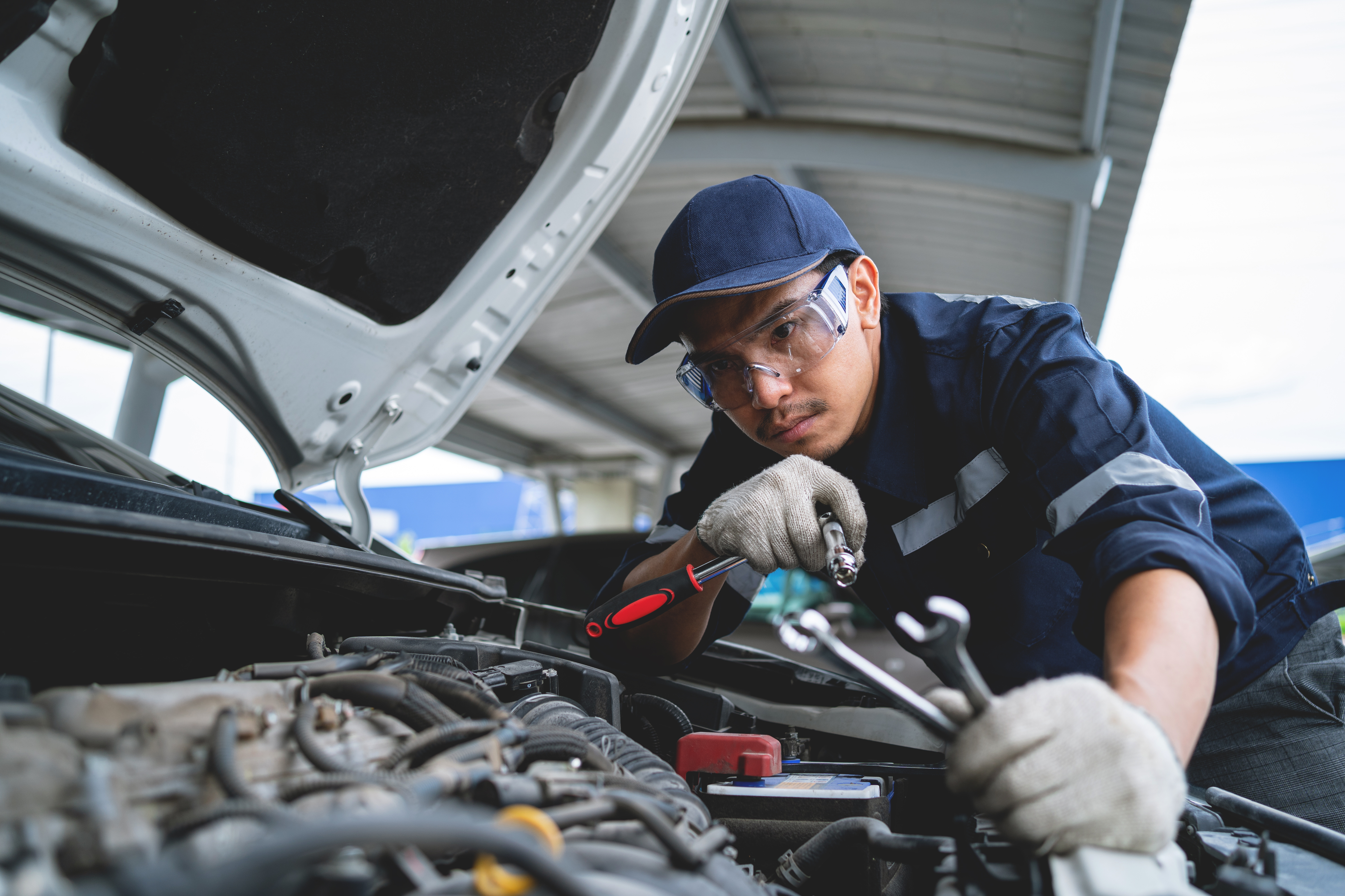 Mechanic holding tire inside auto shop